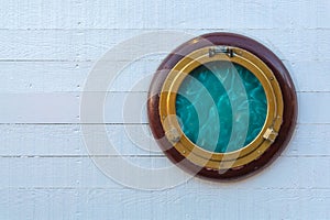 Ship window or porthole on white wooden wall.