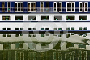 Ship windows with their reflections in water.