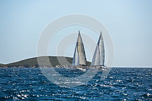 Ship yachts with white sails in the open Sea. Luxury boats.