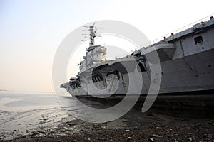 Shipbreaking Yard in Darukhana, Mumbai, India Ã¢â¬â INS Vikrant dismantling with scrap metal & workers in background photo