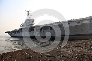 Shipbreaking Yard in Darukhana, Mumbai, India Ã¢â¬â INS Vikrant dismantling with scrap metal & workers in background photo