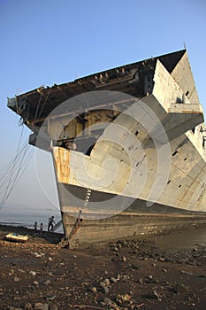 Shipbreaking Yard in Darukhana, Mumbai, India Ã¢â¬â INS Vikrant dismantling with scrap metal & workers in background photo