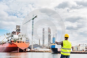 Shipbuilding engineer checking documents at the dock side in a port.