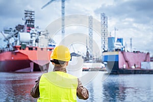 Shipbuilding engineer checking documents at the dockside in a port.