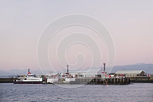 Shipbuilding port and ships at dock with crane at sunset coastal view