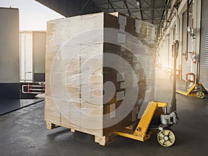 Shipment boxes, Cargo freight truck, Delivery. Hand pallet jack with stack cardboard boxes on pallet loading into cargo container.