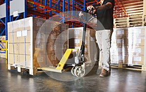 Shipment, Cargo in factory. Warehouse worker working with hand pallet truck. his unloading a large pallet goods in the warehouse s