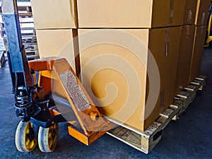 Shipment cartons box on pallets and wooden case on hand lift in interior warehouse cargo for export and sorting goods in freight