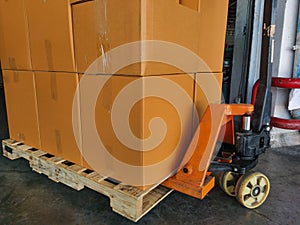 Shipment cartons box on pallets and wooden case on hand lift in interior warehouse cargo for export and sorting goods in freight