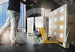 Shipment, Delivery, Cargo export Worker unloading heavy pallet goods, his using hand pallet jack loading into container truck.