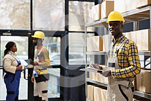 Shipment warehouse manager checking orders list on clipboard portrait