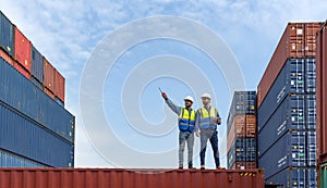 Shipment worker use a walkietalkie to point to container storage location, explain to colleague about planning for next shipment. photo