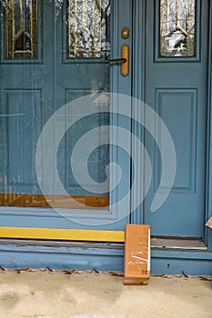 Shipping box on a porch propped up against the front door.