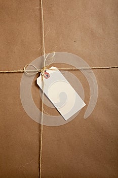 A Shipping Box Ties with string with a blank label