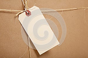 A Shipping Box Ties with string with a blank label