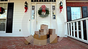 Shipping boxes near beautiful front door decorated for Christmas