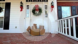 Shipping boxes near beautiful front door decorated for Christmas