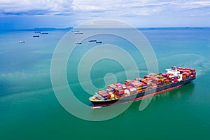 Shipping cargo container transportation on the green sea aerial view