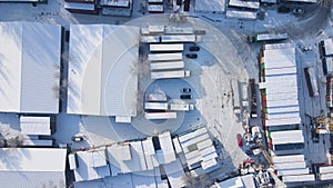 Shipping container and cargo crane at storage yard at winter time aerial view