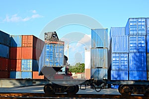 Shipping container loading by richtracker on the freight rail car at logistic warehouse port. Ocean Freight Cargo Shipping,