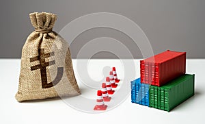 Shipping containers with goods and turkish lira money bag are separated by a barrier.