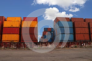 Shipping Containers placed as layered in the storage facility on blue sky background