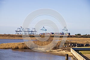 Shipping cranes and colorful shipping containers on the dock along the Mobile River at USS Alabama Battleship Memorial Park