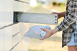 shipping and online buying concept. sending or receiving parcel at self service pickup point machine