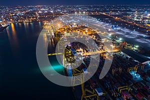 Shipping port and shipping containers cargo at night aerial view