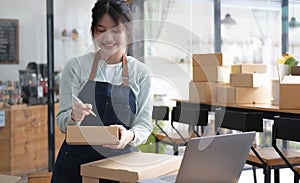 Shipping shopping online ,young start up small business owner writing address on cardboard box at workplace.small business