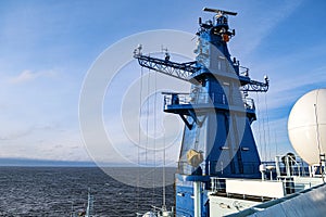 Ships antenna and navigation system in a clear blue sky.