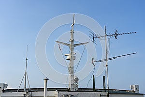 Ships antenna and navigation system on a ferry boat with sunlight and blue sky in background, Thailand