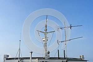 Ships antenna and navigation system on a ferry boat with sunlight and blue sky in background, Thailand