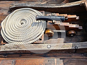 The ships cannon is secured with ropes on the deck of an old wooden sailboat