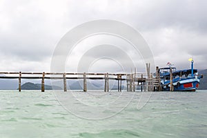 Ships that are docked in old wood , Waiting for tourists, while the rain clouds are forming.