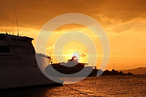 SHIPS AND FERRY AT THE PARKING PORT AT THE SUNSET.