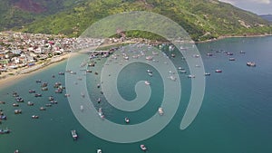 Ships and fishing boat standing in sea bay and blue water and green mountains aerial landscape. Drone view sailing ships