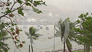 Ships in a harbor under a heavy rain and storm wind. Tropical storm concept. Contains natural sound