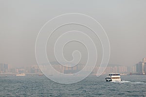 Ships on the lake with the silhouettes of high buildings in the background on a foggy day