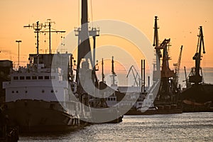 Ships in sea port on sunset background