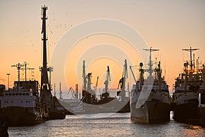 Ships in sea port on sunset background