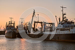 Ships in sea port on sunset background