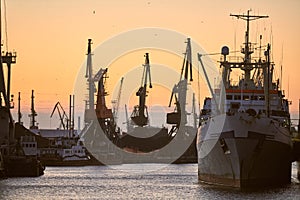 Ships in sea port on sunset background