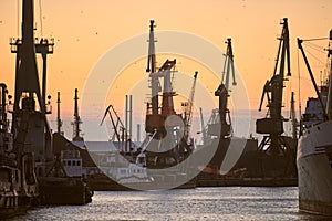 Ships in sea port on sunset background