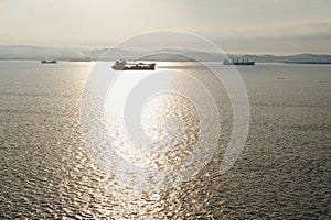 Ships silhouetted on ocean