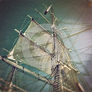 A ships tall mast and sails.