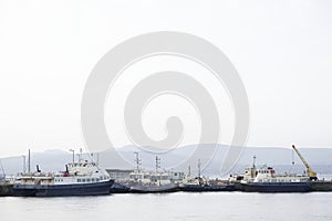 Ships and tug boats with crane in sea port dock