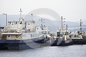 Ships and tug boats with crane in sea port dock