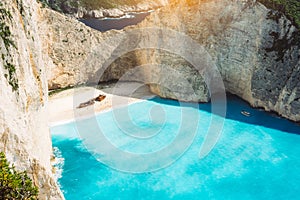 Shipwreck on Navagio beach with turquoise blue sea water surrounded by huge white cliffs. Famous landmark location on