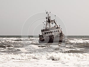 Shipwreck in wild Atlantic Ocean at Skeleton Coast, Namibia, Africa